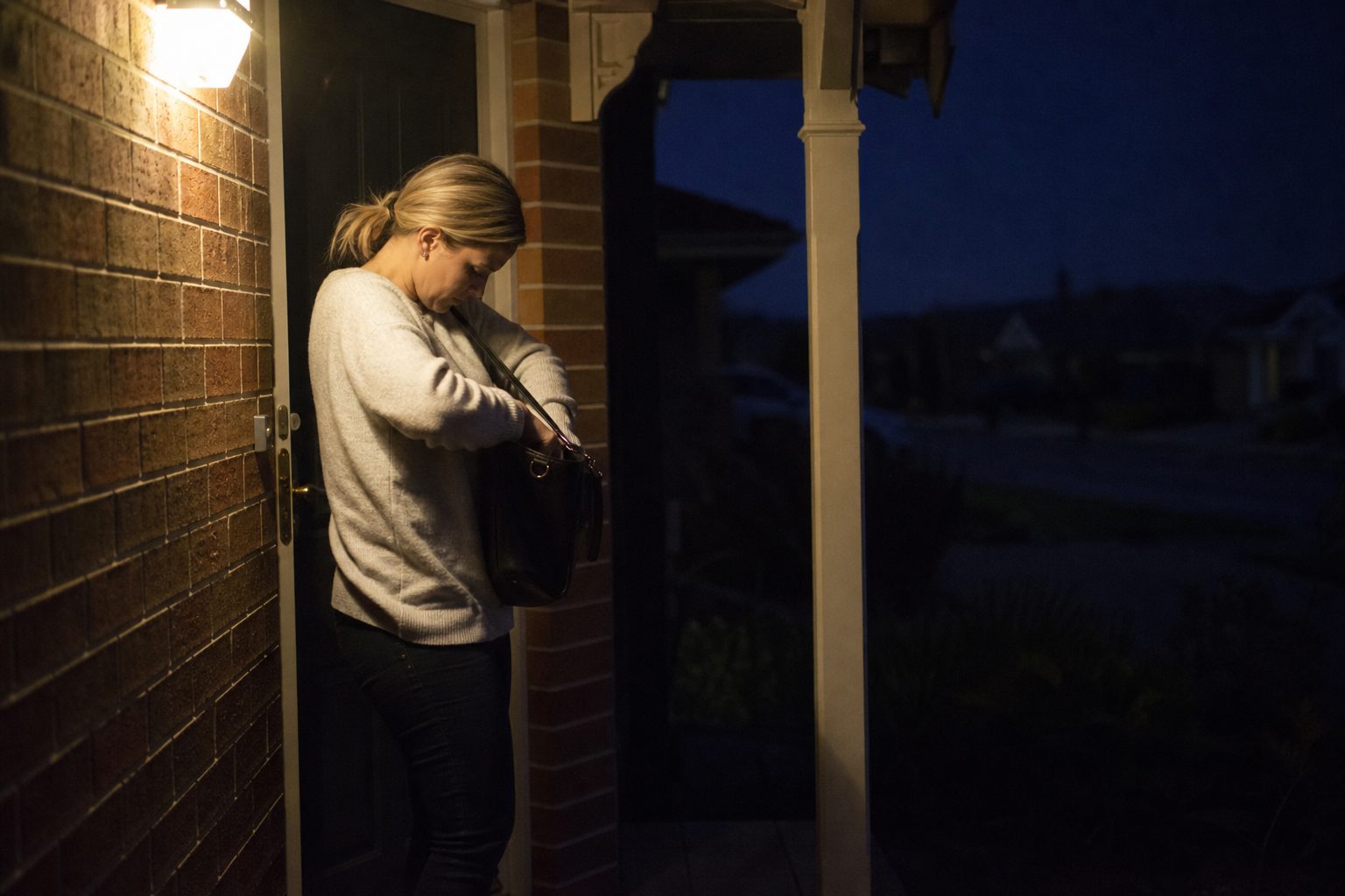 A person locked out at their front door at night